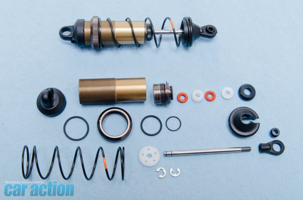 The messiest part of the build was next; building the shocks. Standard two o-ring sealing is used on the shock bottom. The plastic top shock cap has a bleeder screw to aid in the bleeding process once you have filled the shock up with oil. Here are all the parts that make the SC6 shocks and a complete one.